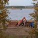a crane is working on a pile of logs